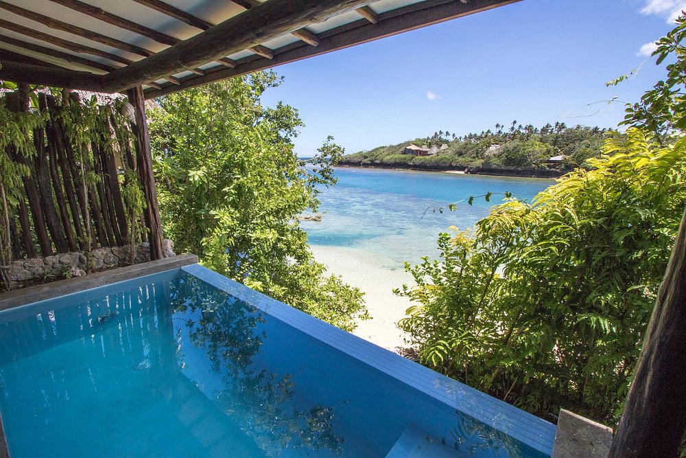 Private villa pool surrounded by tropical gardens at Savasi Island Resort, Fiji, overlooking the South Pacific for a luxury all-inclusive getaway.
