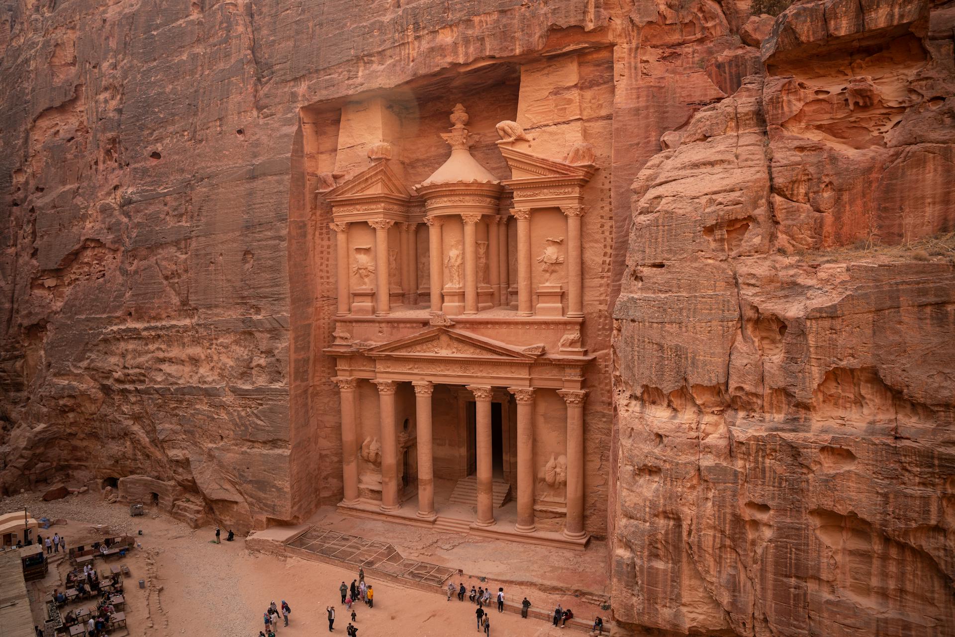 Aerial view of Petra, Jordan with tourists and camels, ideal for cultural and historical travel tours.