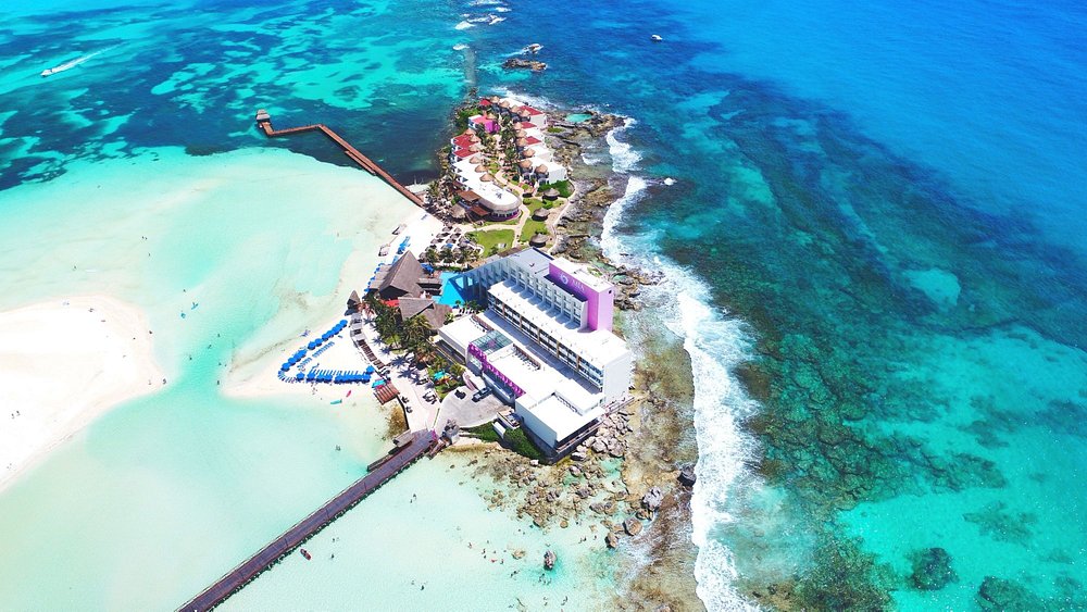 Ariel view of Mia Reef hotel, Isla Mujeres, Mexico, showing the shallow, calm turquoise Caribbean Ocean all around it.