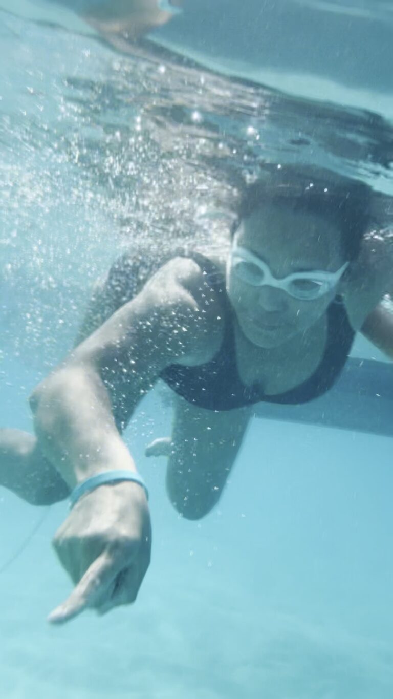 Person pointing toward the ocean floor in crystal clear water about 15 feet deep at Meads Bay Anguilla.